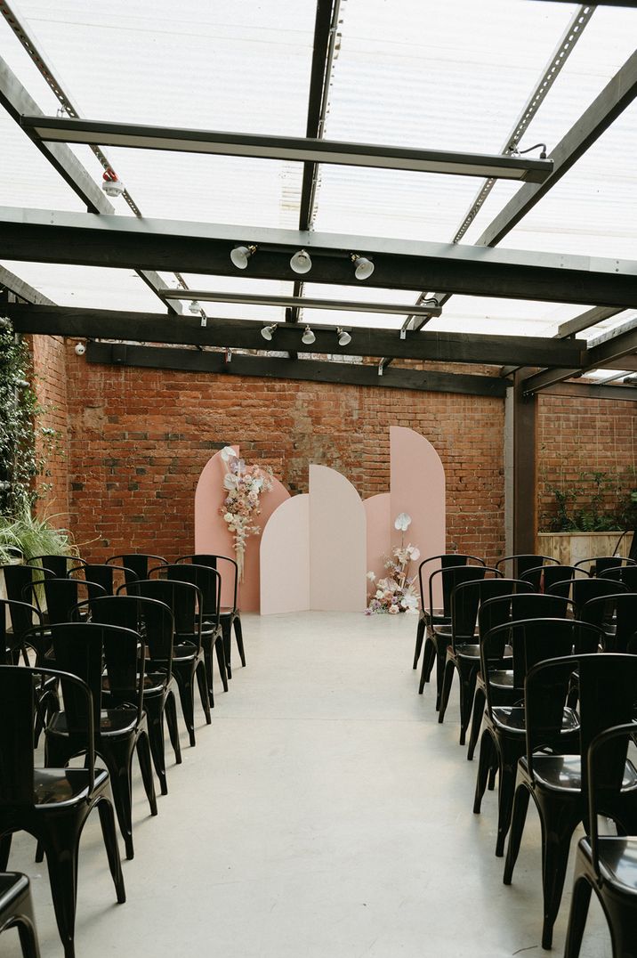 Pink and neutral arched wedding altar decoration at the industrial wedding venue, The Shack Revolution 