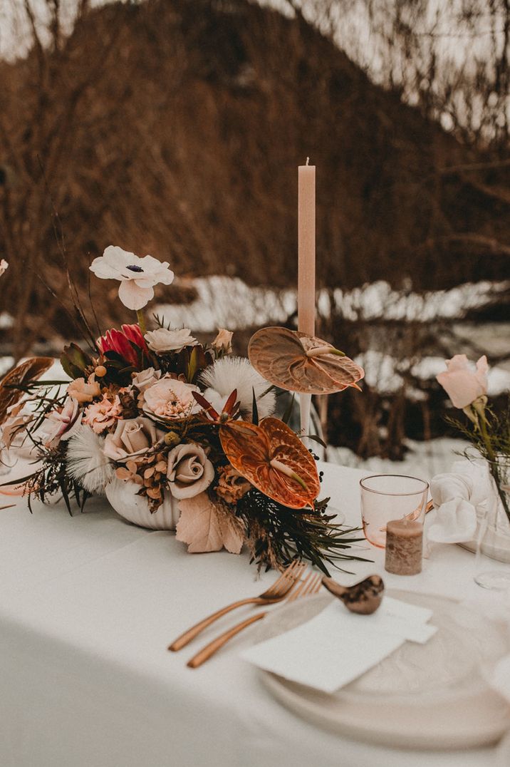 Anthuriums, king proteas, roses, anemones and more neutral toned flowers in white bowl for table centrepiece 