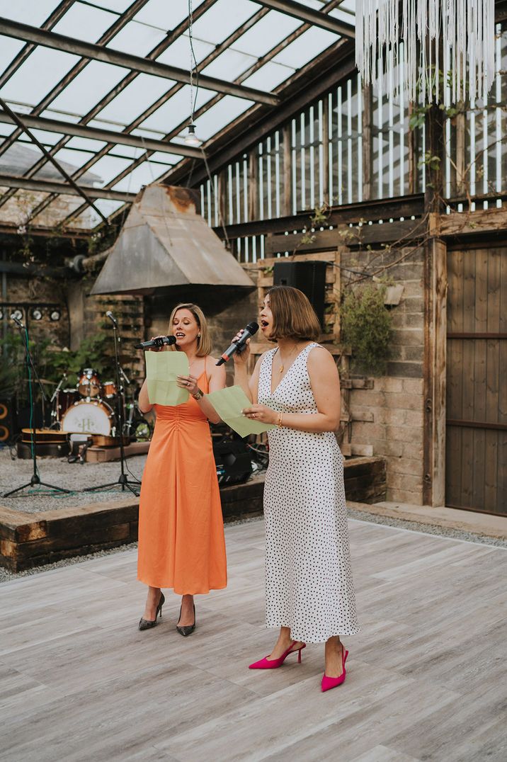 The two maids of honour perform a joint wedding speech for the bride and groom at glasshouse wedding 