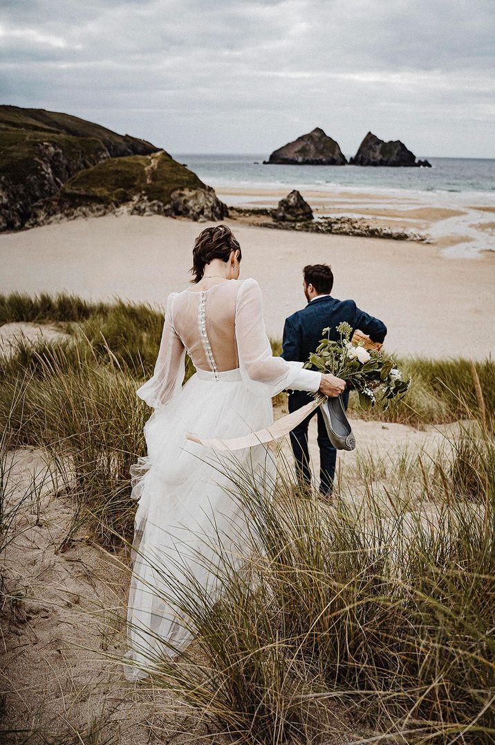 Bride and groom going to the Cornish beach for their couple portrait photos at Treseren 