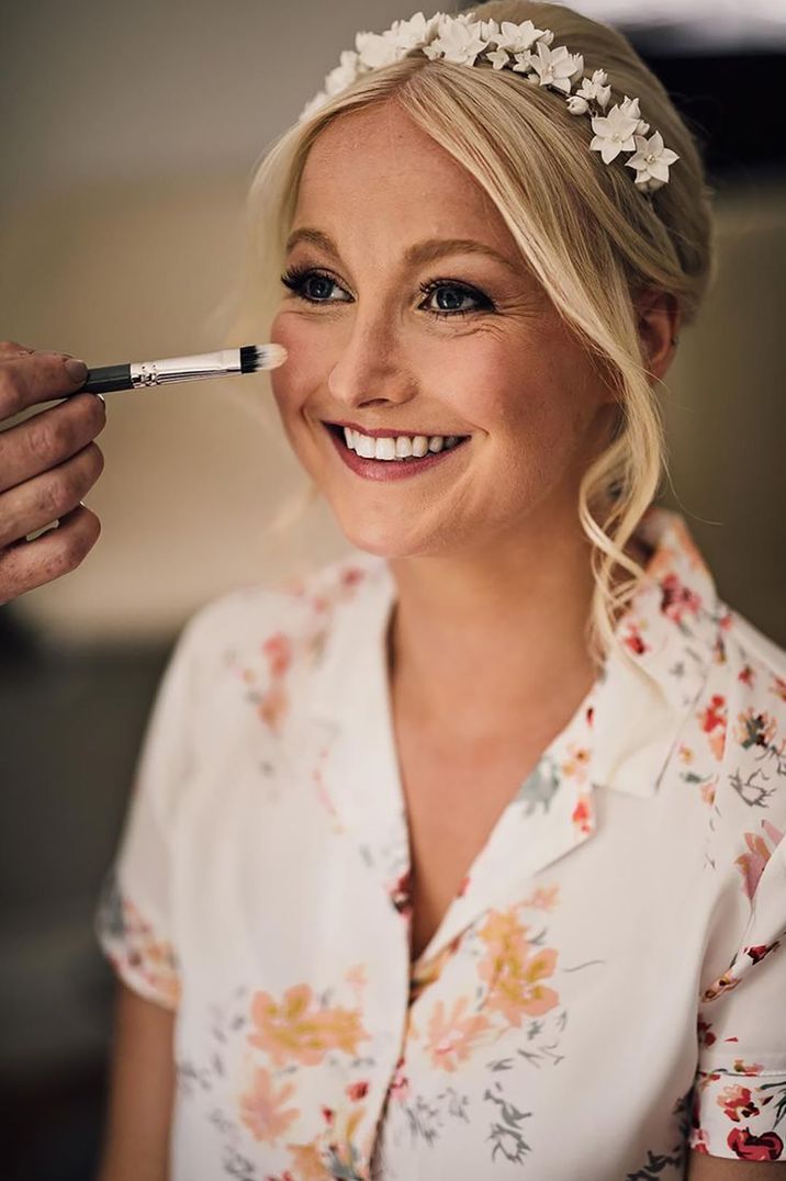 Bride wearing white flower enamel crown gets makeup done for the wedding 