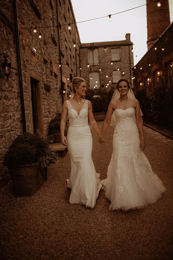 Holmes Mill Lesbian wedding with two bries in a strapless lace wedding dress and fitted fishtail wedding dress holding hands 