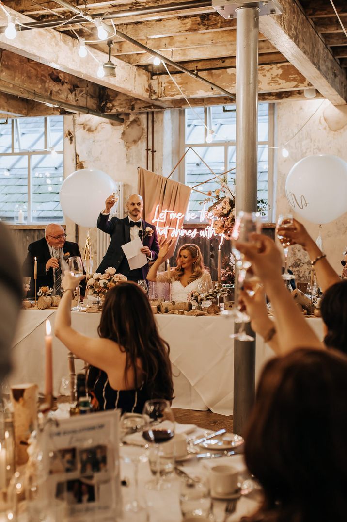 Wedding guests raising glasses during speech at Holmes Mill wedding