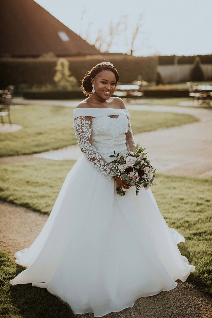 Bride in a princess skirt wedding dress with off the shoulder detail and a lace bodice 