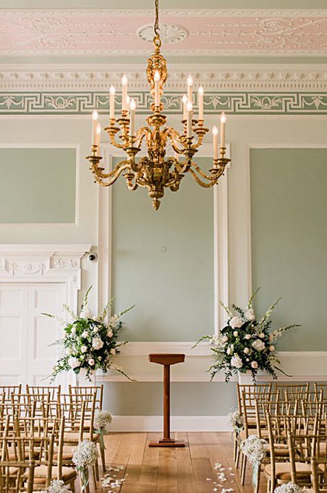 Reception room of Botleys Mansion - light green walls, large golden chandelier, large floral arrangements with dried flower, eucalyptus and white rose 