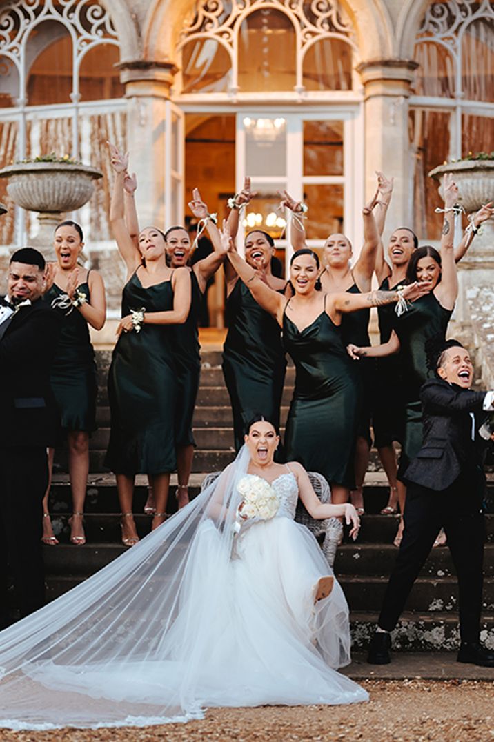 Wedding party in black tie with bridesmaids in satin gowns 