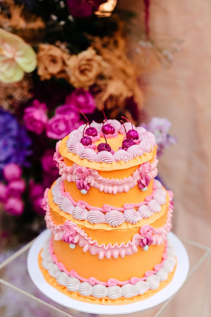 Two tier bright orange iced retro wedding cake for summer wedding 