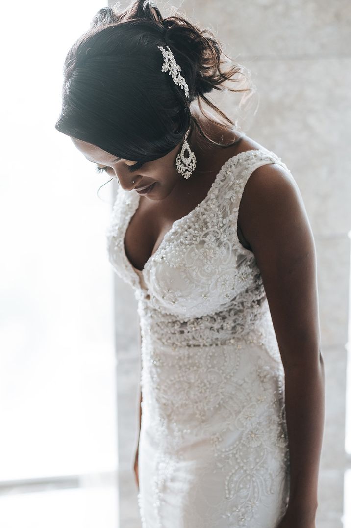 Black bride in a lace wedding dress wearing diamanté pendant earrings 