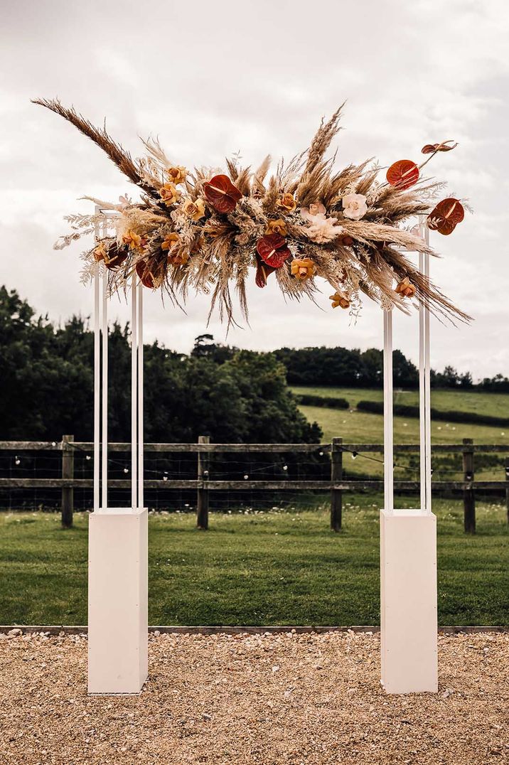 Boho and rustic pampas grass installation with autumnal roses and anthuriums 