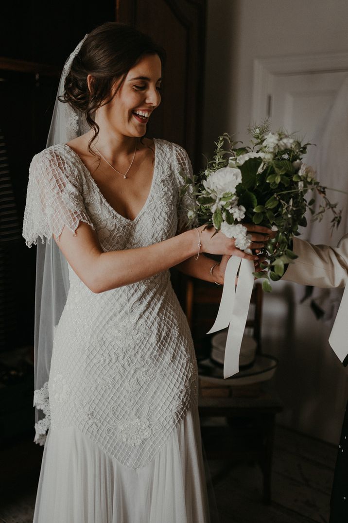 Embellished beaded short sleeve wedding dress worn by bride with embroidered edge lace veil 