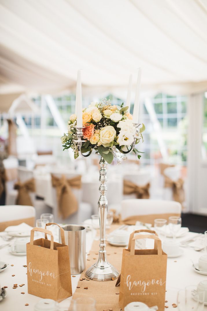 Typewriter font wedding tablescape with brown paper bags, white roses and silver candle sticks