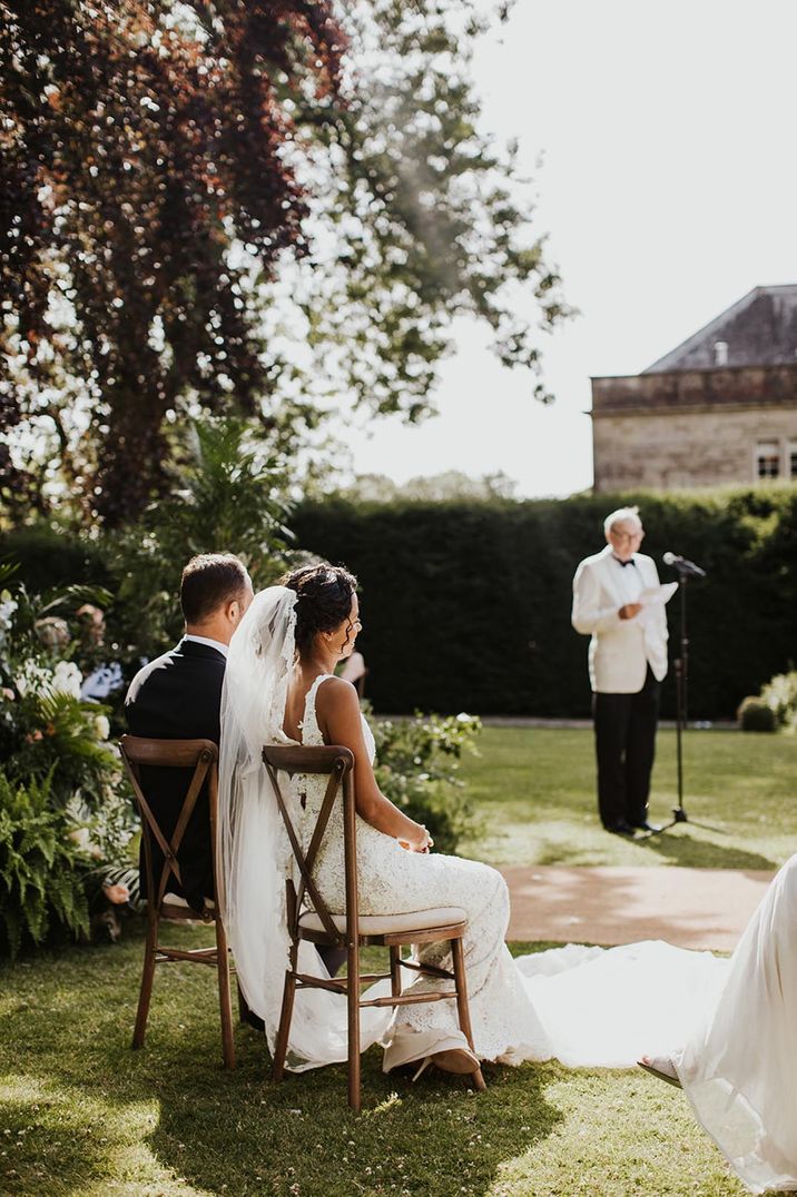 Bride in Pronovias wedding dress and groom listening to the wedding readings during the ceremony