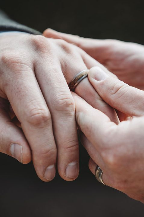 Groom and groom holding hands showing off their new wedding rings