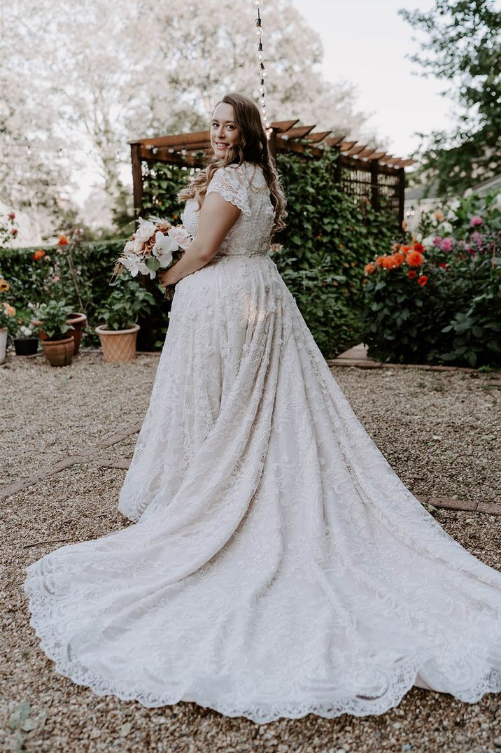 Bride in lace wedding dress with a long train for classic DIY garden wedding with handmade wedding dress 