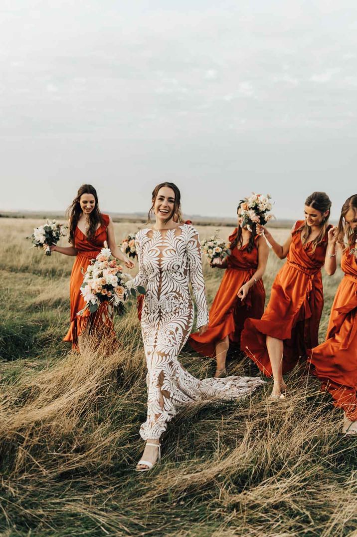 Bride in a Rue De Seine boho lace wedding dress with her bridal party in burnt orange bridesmaid dresses