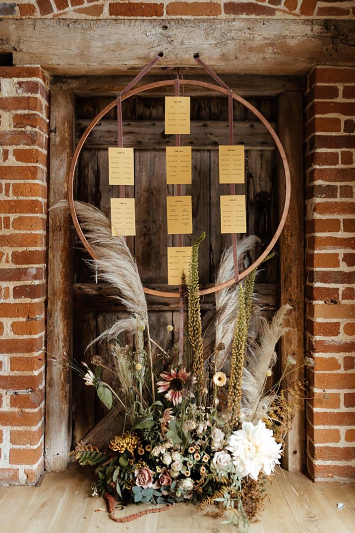 Warm toned hoop table plan with dried grass flower arrangement