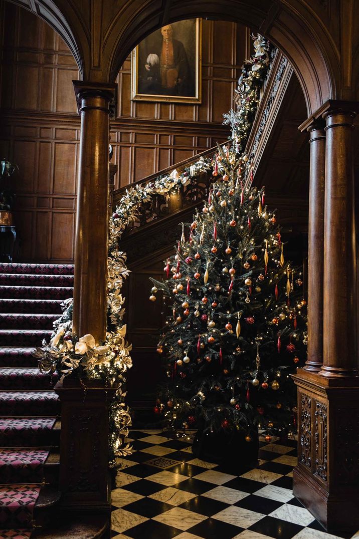 Grand country house wedding venue with red and gol decorations on the Christmas tree for a winter wedding 