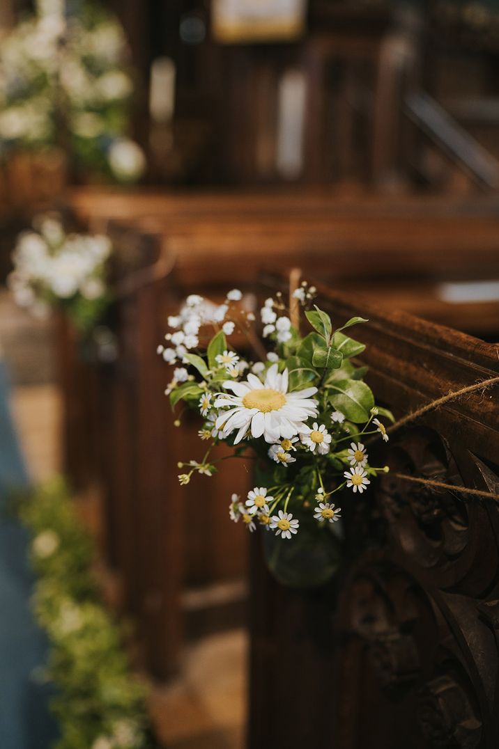 April birth flowers with church pews decorated with daisies and foliage 