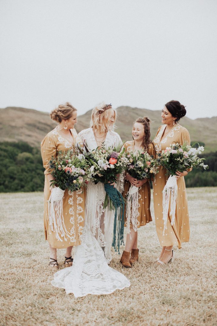 Bridal party portrait with bridesmaids in yellow dresses and the bride in a lace boho wedding dress