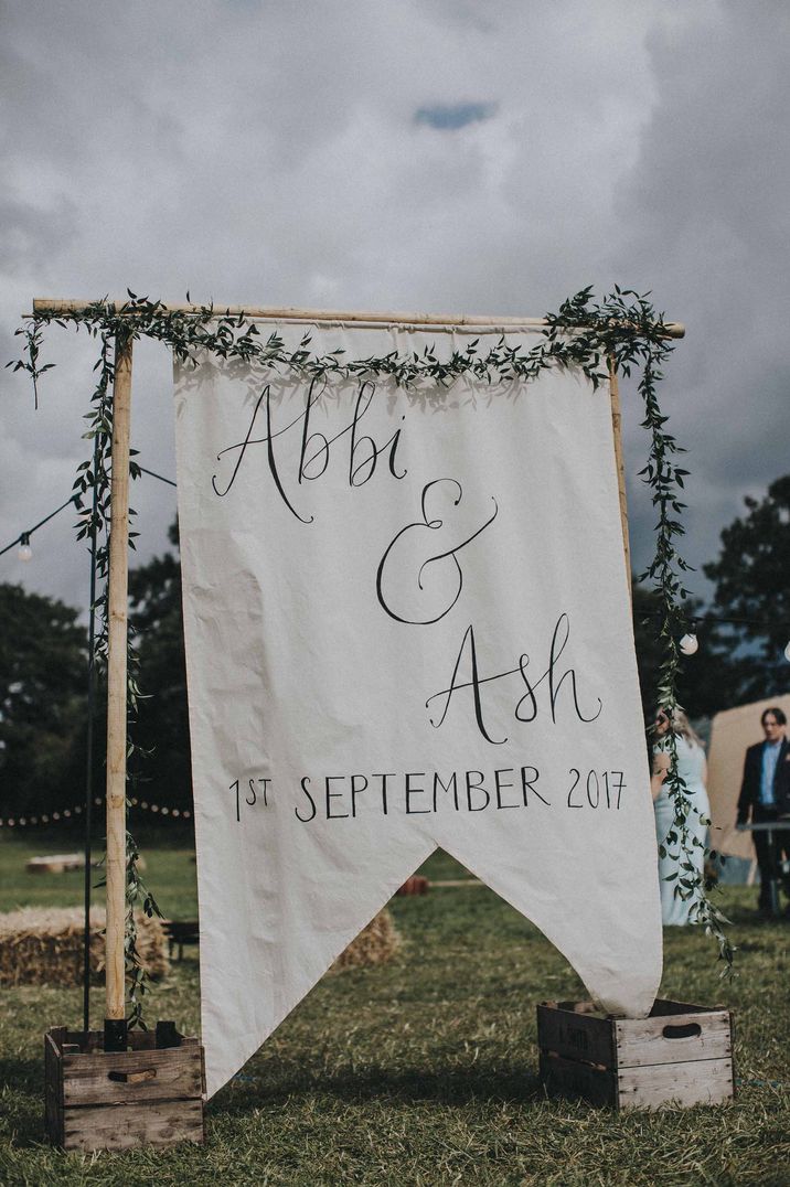 Large fabric wedding sign at outdoor boho wedding