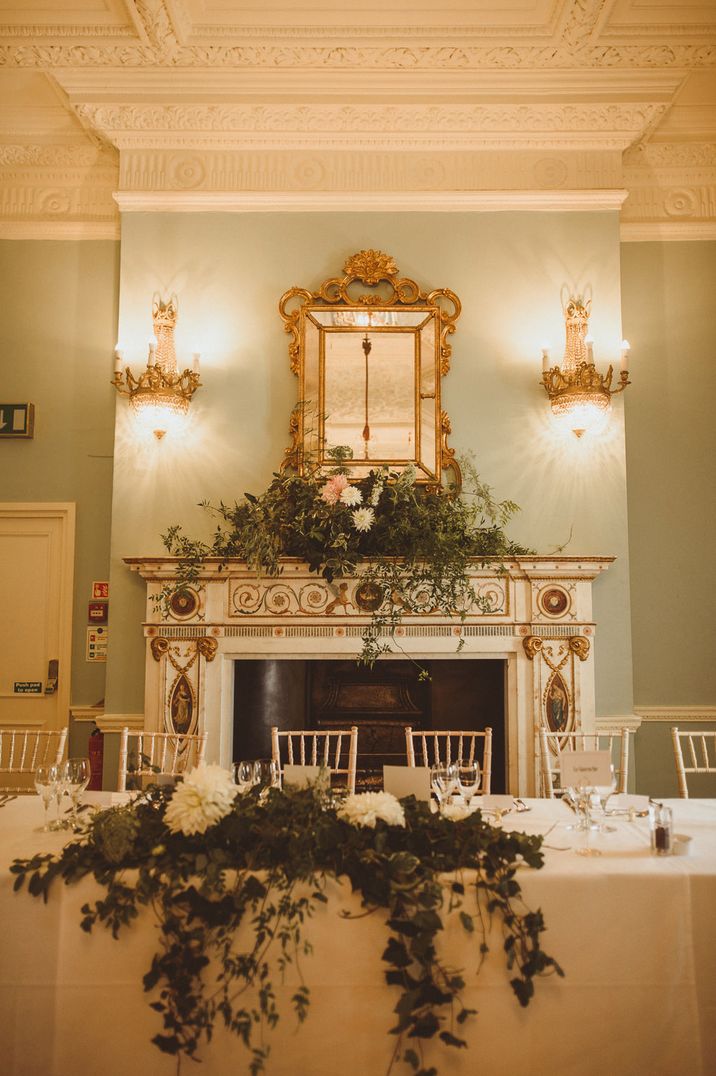 Carlton House Terrance wedding reception with white flowers and green foliage fireplace arrangement 