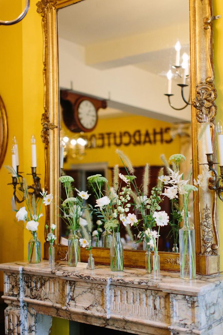 wedding flowers in stems on the fireplace mantel at Brunswick House