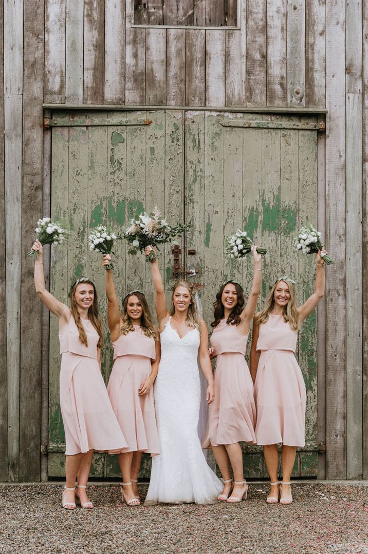 Boho wedding with bridesmaids in pink midi dresses with matching high heel shoes with an ankle strap 