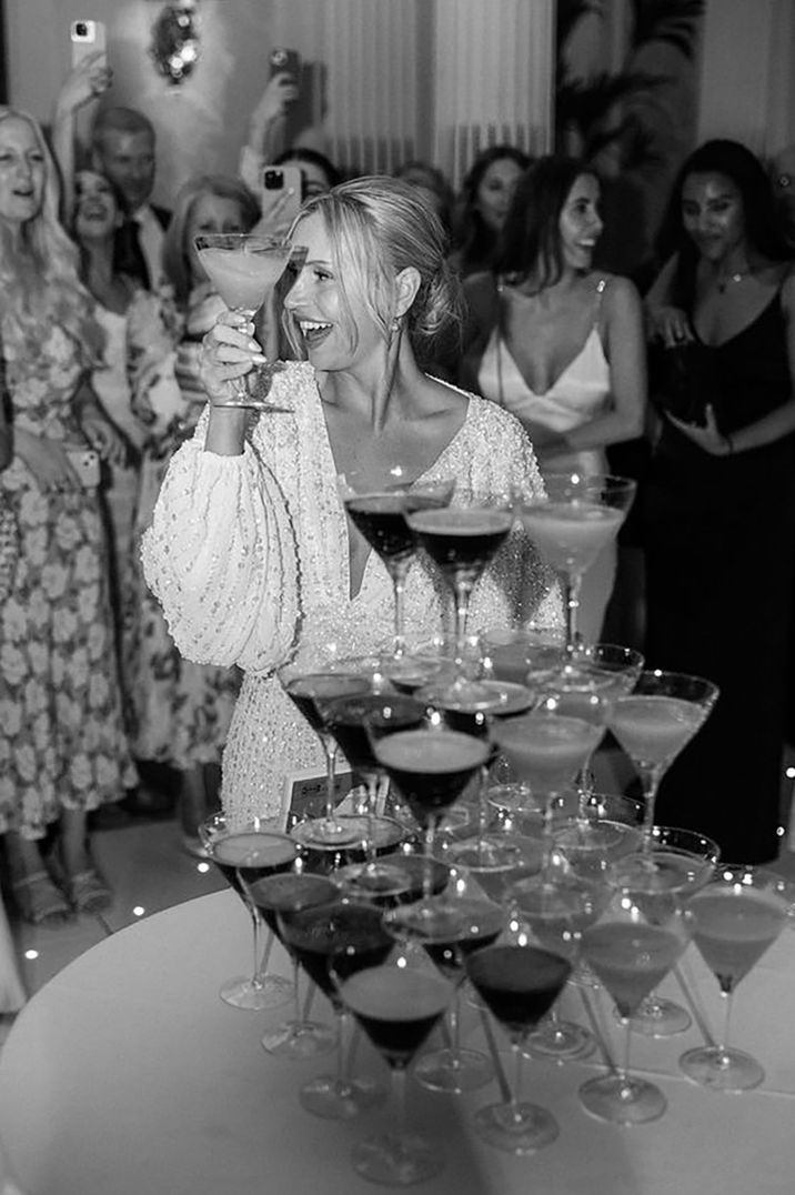 Bride with espresso martini tower during party by Romy Lawrence Photography