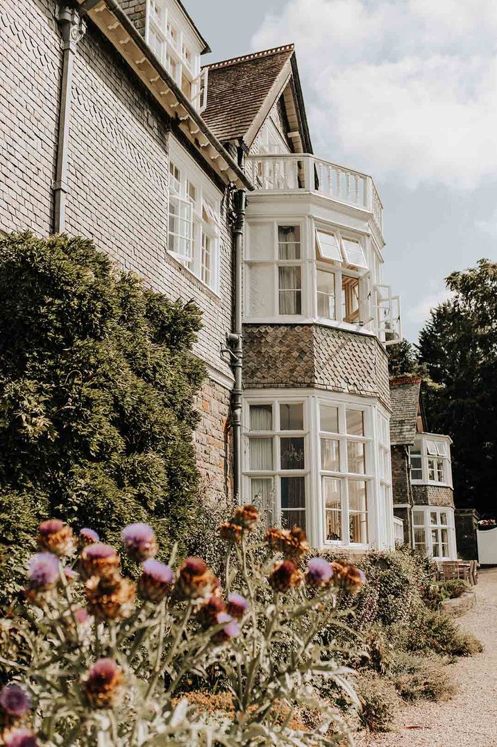 The exterior of Plas Dinam country house wedding venue with spring florals