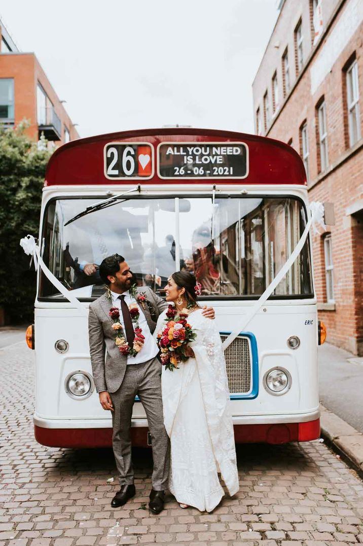 Large white and red wedding bus at Indian British wedding in Sheffield with white ribbon decor