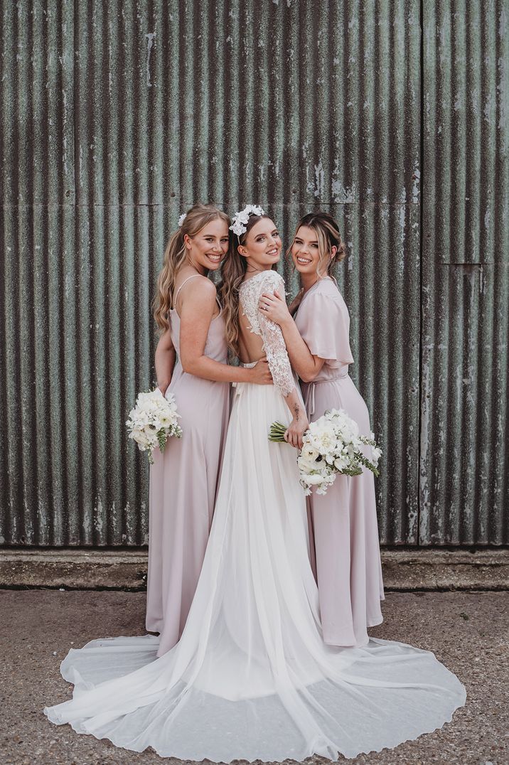 Bridesmaids in pastel pink bridesmaid dresses with the bride in a lace wedding dress for Willow Grange Farm wedding 