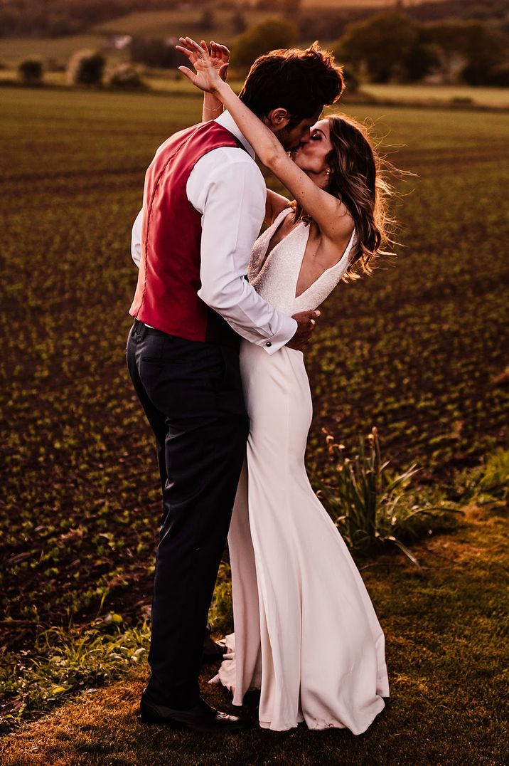 The bride and groom share a beautiful embrace with the bride wearing a beaded sparkly wedding dress