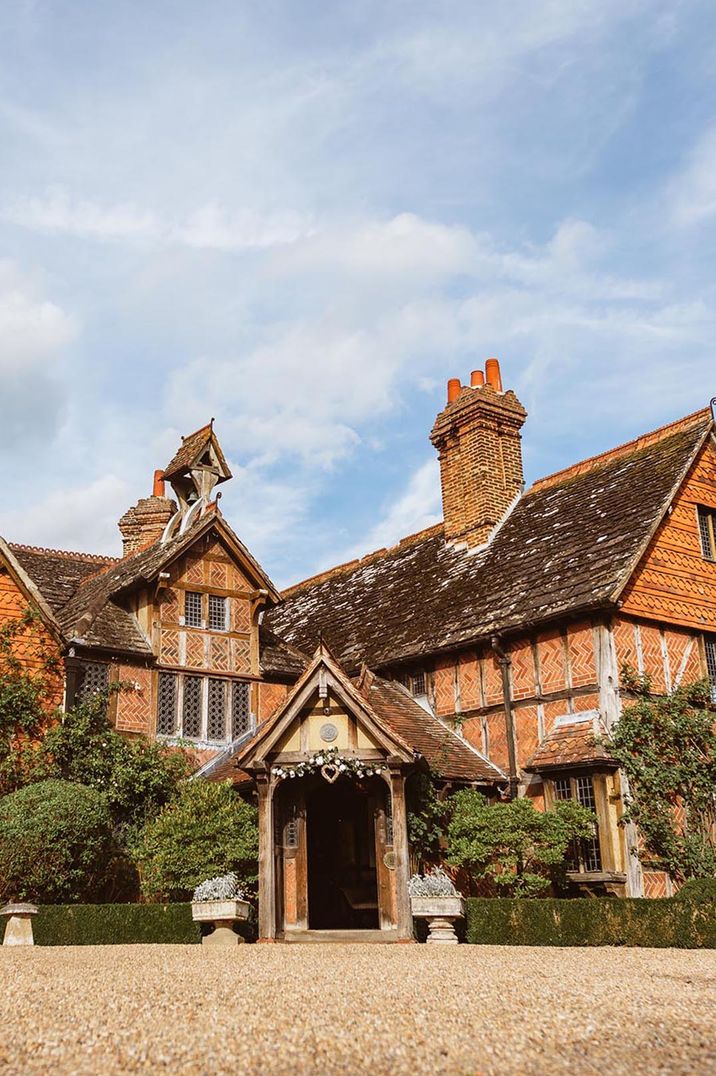 Surrey wedding venue in Langshott Manor with white floral entrance decorations 