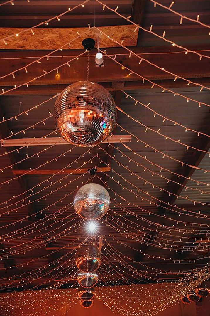 Image of disco ball and fairy lights decoration on the ceiling by Amy Chapple Photography