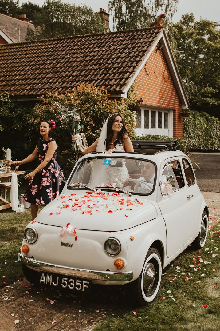 White Fiat 500 wedding cars with pink and red petals on bonnet