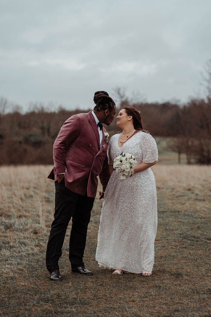 Bride in sparkly sequin wedding dress with groom in dusky pink suit jacket for under 5k wedding 