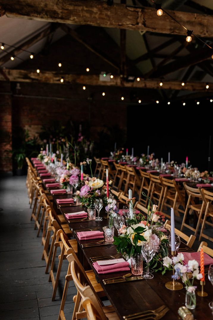 Pink napkins with gold cutlery and candlesticks with different coloured pastel candles 