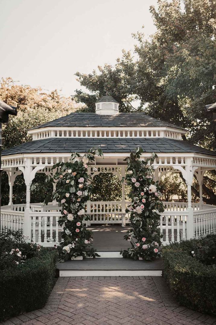 Wedding pagoda at The Old Kent Barn wedding venue with garden rose, peony and foliage floral columns 