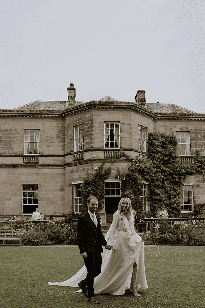 The bride and groom walk around the grounds of their Yorkshire wedding venue, Middleton Lodge Estate 