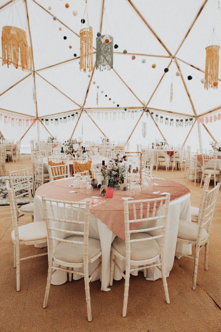 Geodome boho wedding reception with wildflowers and macrame chandeliers 