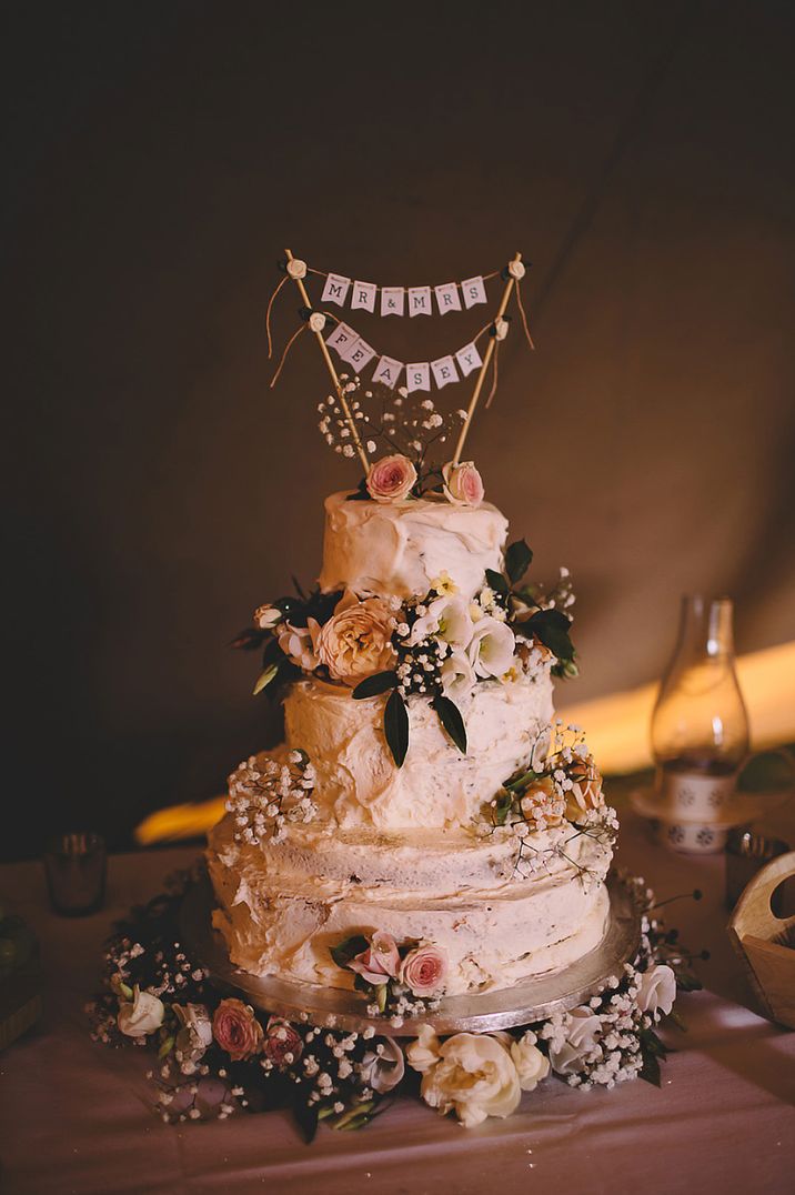 Three-tier buttercream wedding cake with bunting wedding cake topper 