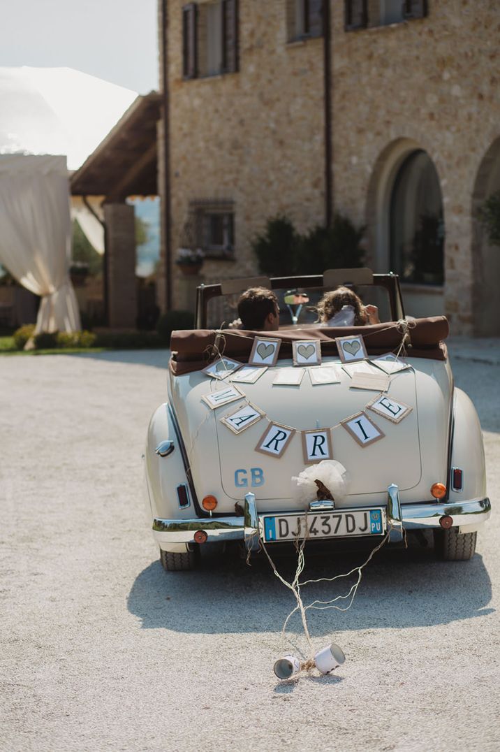 Convertible wedding car with bunting and tin can decorations