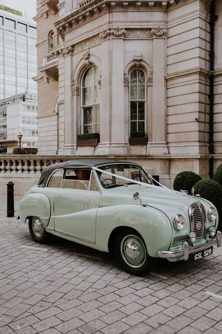 Mint green vintage wedding car with white wedding ribbon decoration