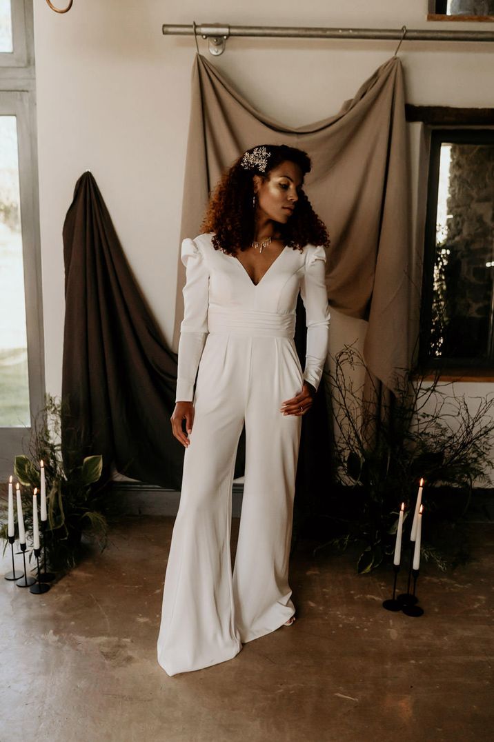 Black bride with curly hair wearing a wide leg trouser jumpsuit with long sleeves