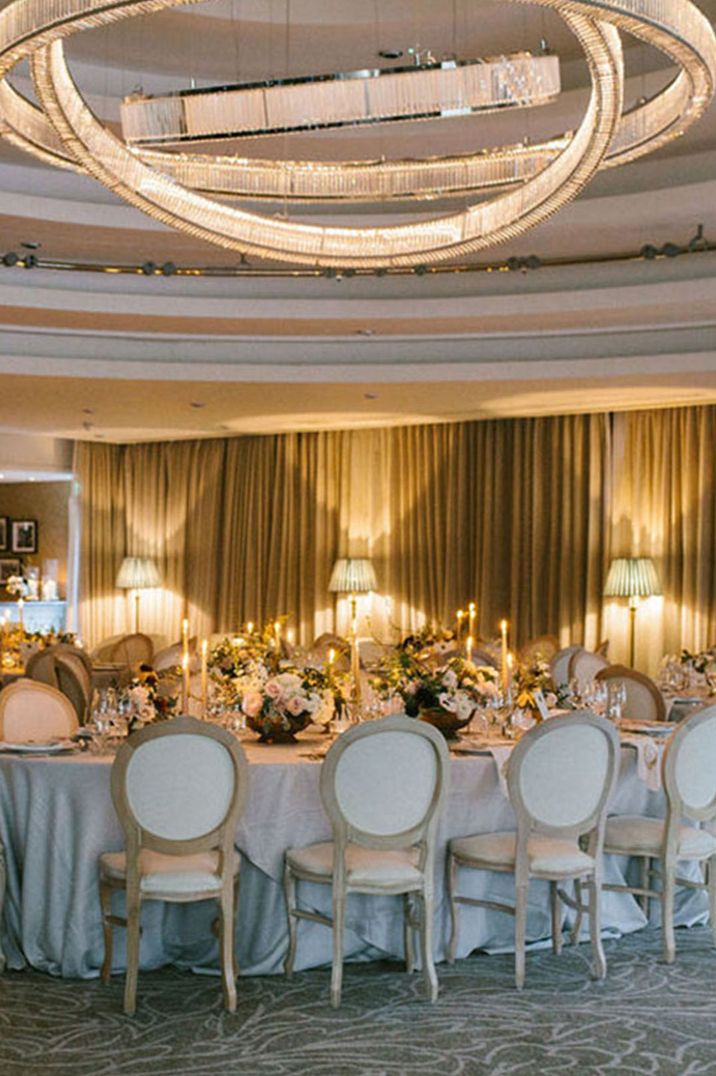 Luxury indoor tablescape with crystal lighting and classic white wedding theme 