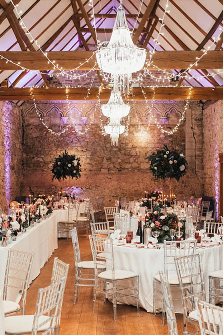 Notley Abbey winter wedding venue with chandeliers and fairy lights over the wedding tables decorated with tall table centrepieces 