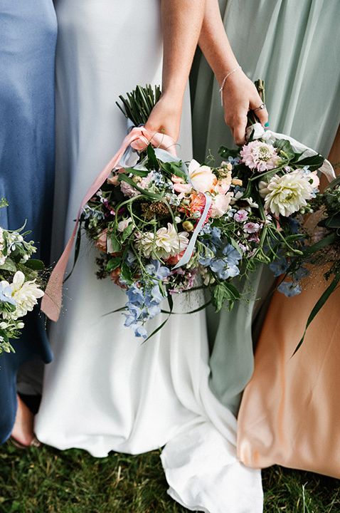 Bridesmaids wearing mismatched bridesmaid dresses with pastel wedding bouquets 