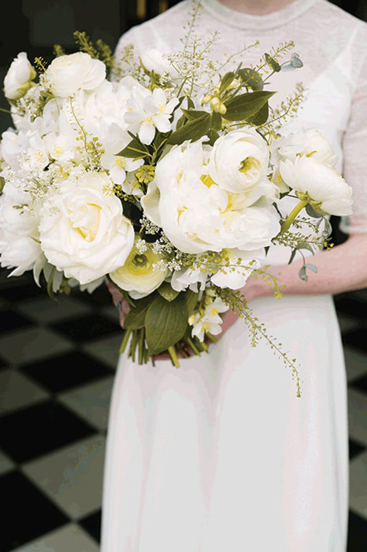 Large white and green bouquet held by bride