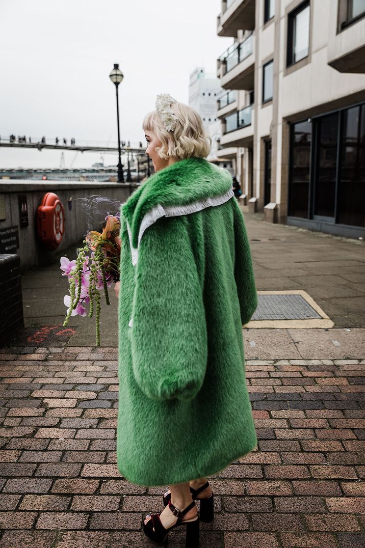 Bride wears long green faux fur vintage styled cover up 