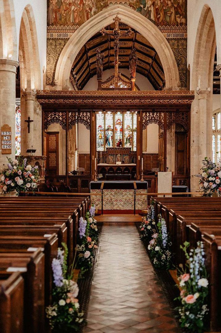 Ceremony room of Culden Faw Estate with classic rose and foliage aisle flowers and stain glass windows 